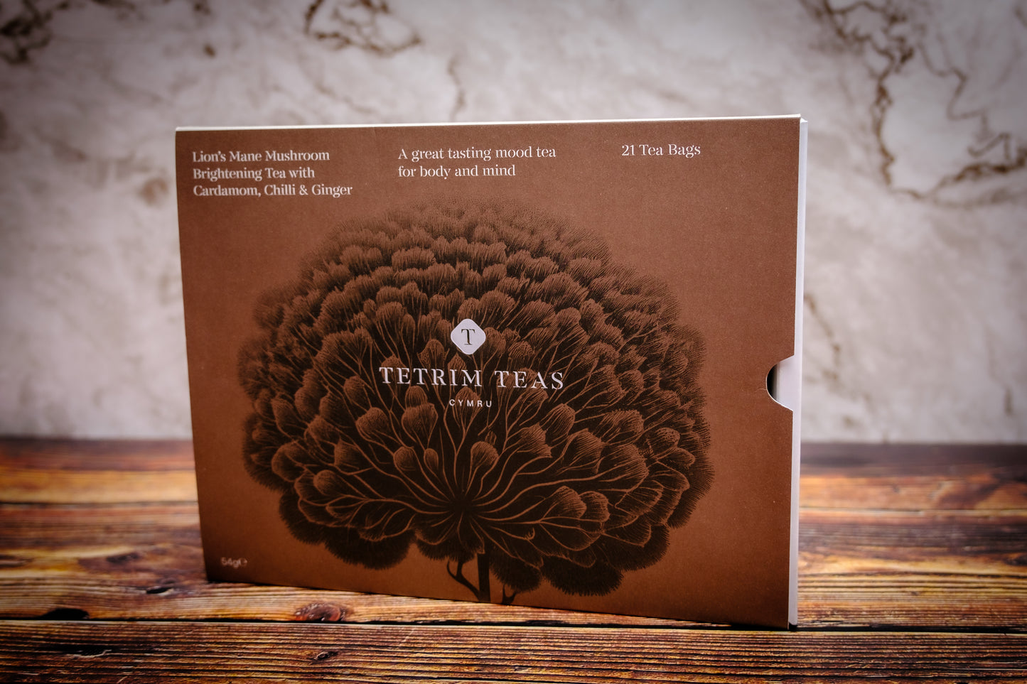 Packaging of Lion's Mane Mushroom Brightening Tea with Cardamom, Chilli & Ginger by Tetrim Teas, featuring a brown label with a floral design.