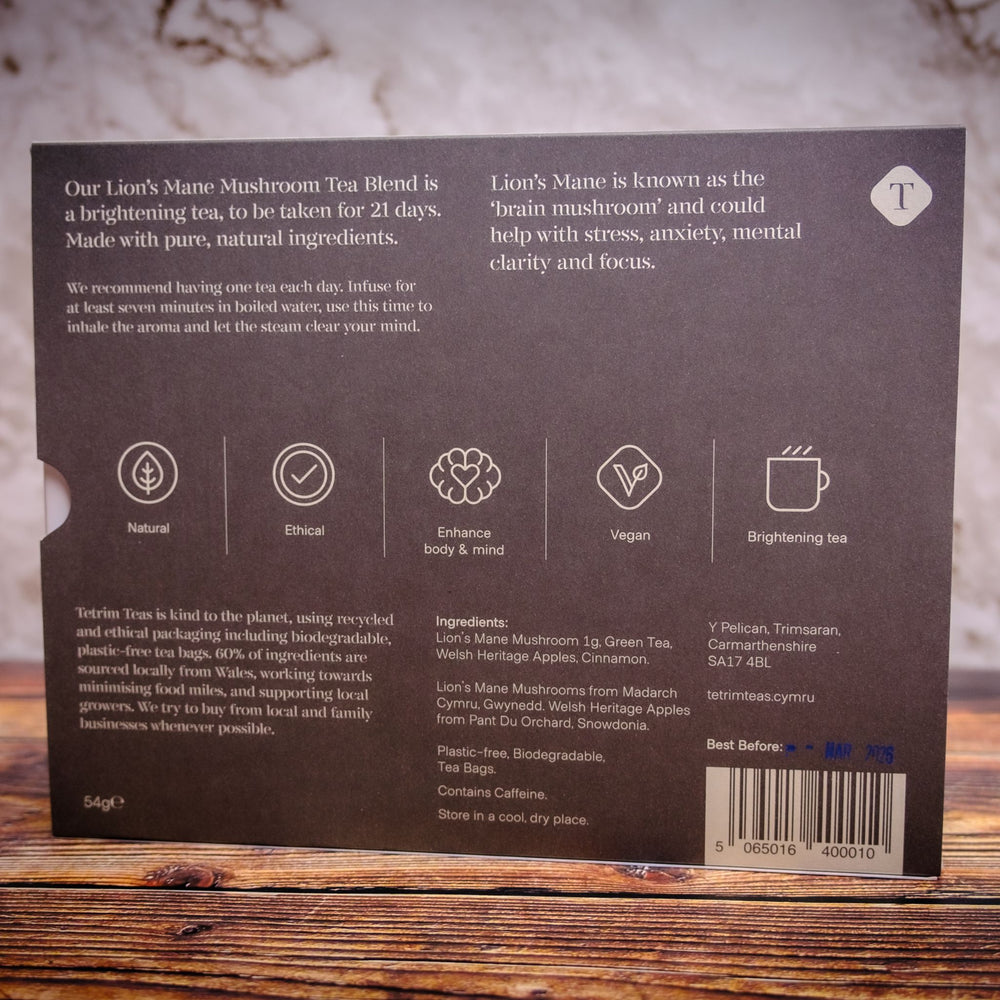 Back of a tetrim lions mane mushroom apple cinnamon tea package with text and icons on a wooden surface