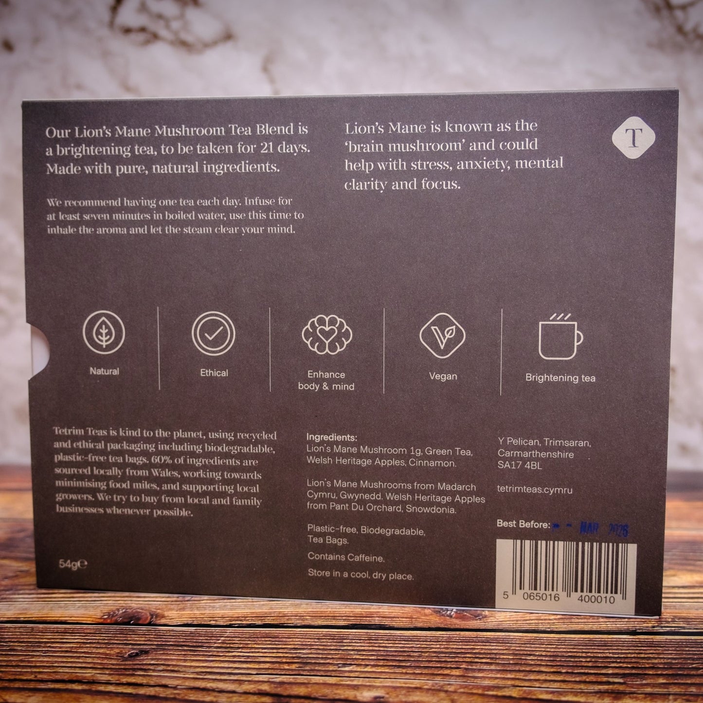 Back of a tetrim lions mane mushroom apple cinnamon tea package with text and icons on a wooden surface