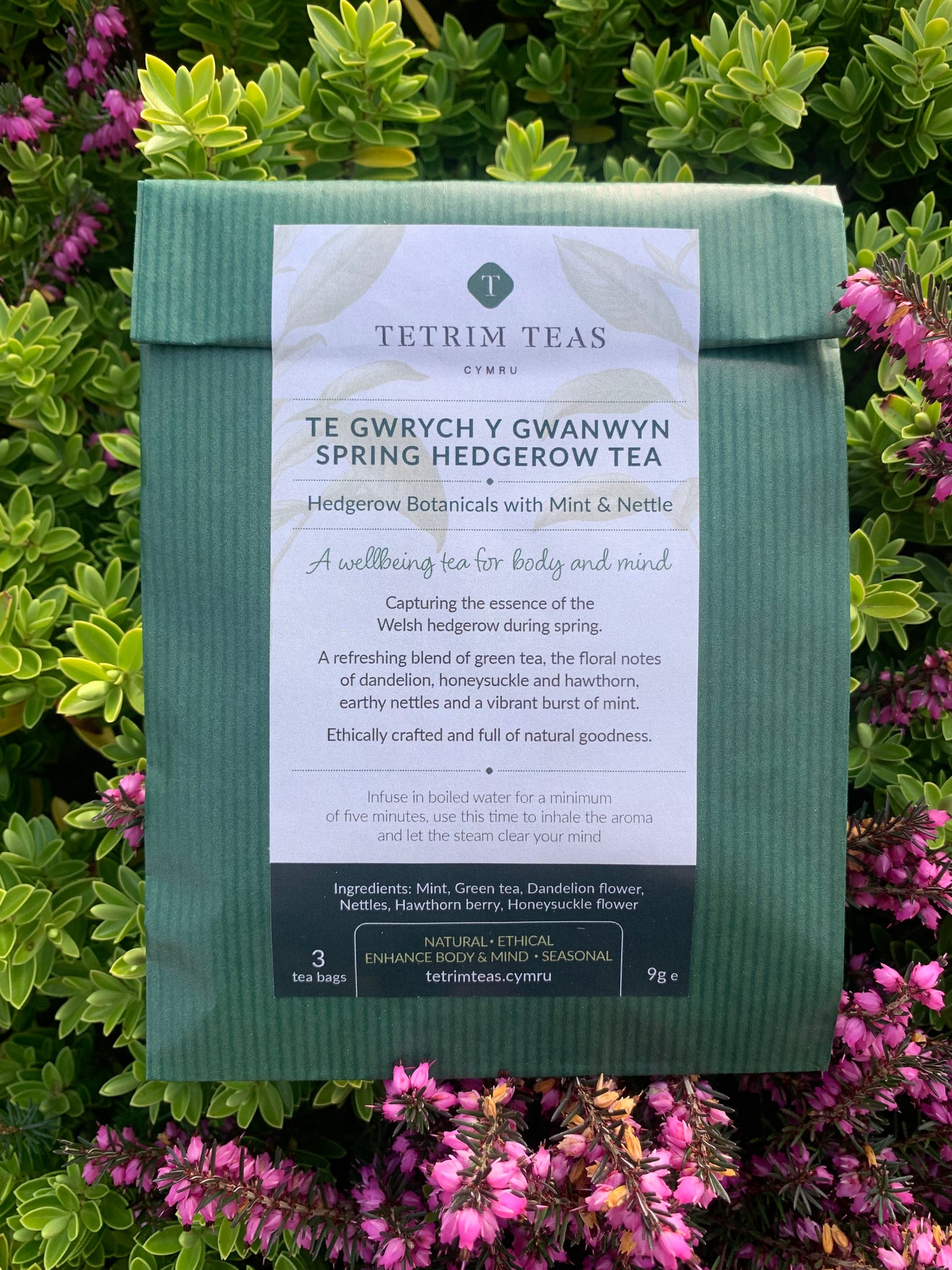 
                  
                    A packaged tea product labeled 'Spring Hedgerow Tea' with with hedgerow foliage in the background.
                  
                