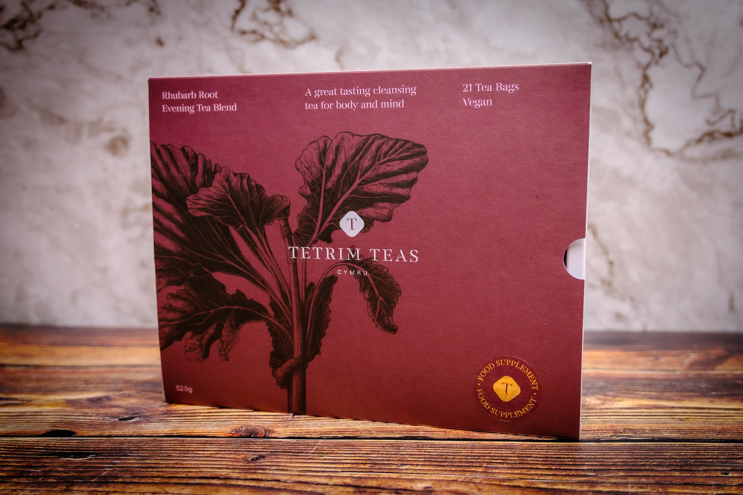 A box of Tetrim Teas rhubarb root cleansing tea with a graphic of a rhubarb leaf on the front. The box is red with white and darker red text and detailing.